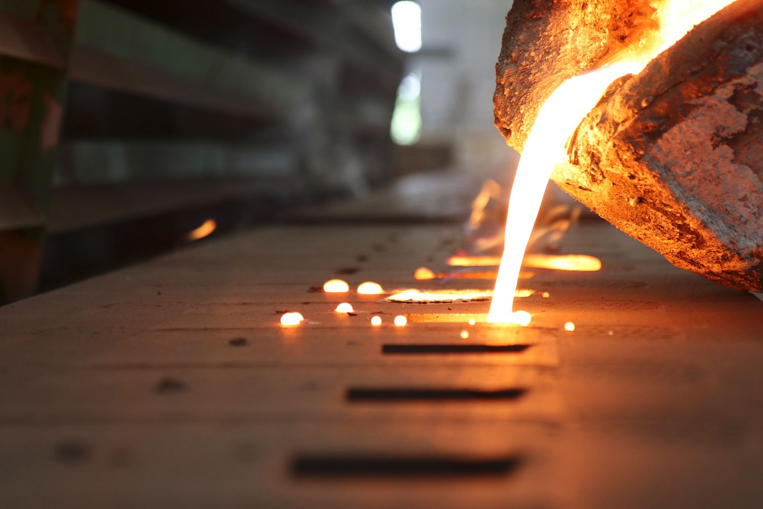 Flüssiges Metall, das in eine Form gegossen wird. Mit einem Industrieofen von ELIOG können sämtliche Schritte der Metallverarbeitung, inkl. Metallurgie, durchgeführt werden.